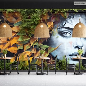 May include: A cafe interior with four black metal tables and chairs. The wall is decorated with a mural of a woman's face with green vines and yellow leaves. There are four woven pendant lights hanging from the ceiling.