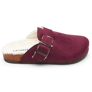 May include: Burgundy suede clog with a buckle closure and a faux fur lining. The clog has a cork platform sole.