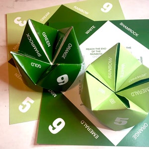 Może przedstawiać: Zielona gra w przepowiadanie przyszłości z napisami "Shamrock", "Emerald", "Orange", "White", "Rainbow", "Mint", "Green", "Cream", "Gold" oraz liczbami "9" i "5" nadrukowanymi na bokach.