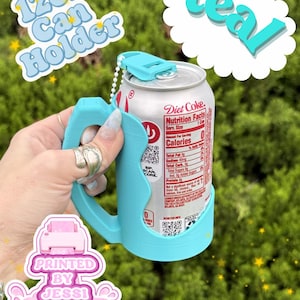 May include: A teal 12oz can holder with a handle and a top tab, holding a silver Diet Coke aluminum can. The text 12oz Can Holder and teal are visible in the image, along with a logo that reads Printed By Jessi in a pink graphic.