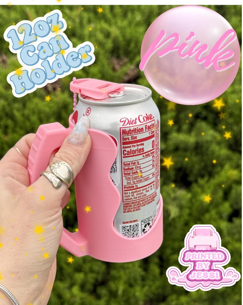 May include: A light pink 12oz can holder with a handle and a small top tab, holding a silver Diet Coke can. The text 12oz Can Holder, Pink, and Printed By Jessi appears in the image. The holder features a contoured grip and a chain attachment.