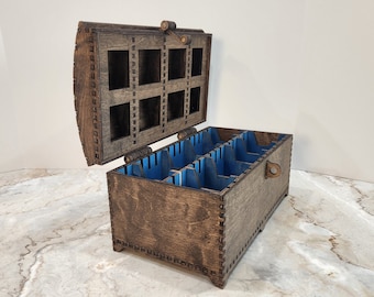 May include: A wooden box with a hinged lid and a latch. The box has a dark brown stain and is decorated with a decorative border. The inside of the box is divided into compartments lined with blue felt.