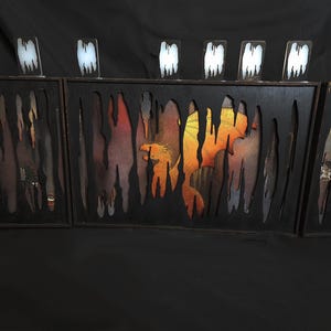 May include: Three black framed shadow boxes with a textured, dripping paint effect. Each box contains a colorful abstract painting with a variety of colors, including orange, yellow, red, and blue.