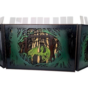 May include: A multi-panel wooden Dungeon Master screen with a forest and dragon design. The screen is black with green and brown accents. The text "Dungeon Master" is visible on the front panel. The screen is designed to stand upright.