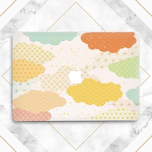 May include: A laptop case featuring a colorful cloud pattern in shades of orange, yellow, green, and blue. The design incorporates various geometric shapes and patterns on a cream background. The Apple logo is visible.