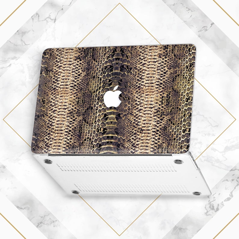 May include: A white laptop computer with a snakeskin pattern on the lid. The Apple logo is visible on the lid.