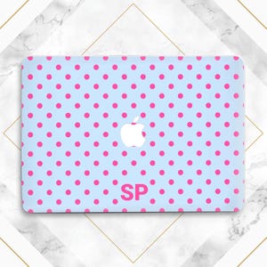 Op de afbeelding: Een lichtblauwe laptophoes met een patroon van roze stippen. Het heeft een wit Apple-logo en de roze initialen "SP". Het ontwerp is eenvoudig en speels, ideaal voor het personaliseren van een laptop.