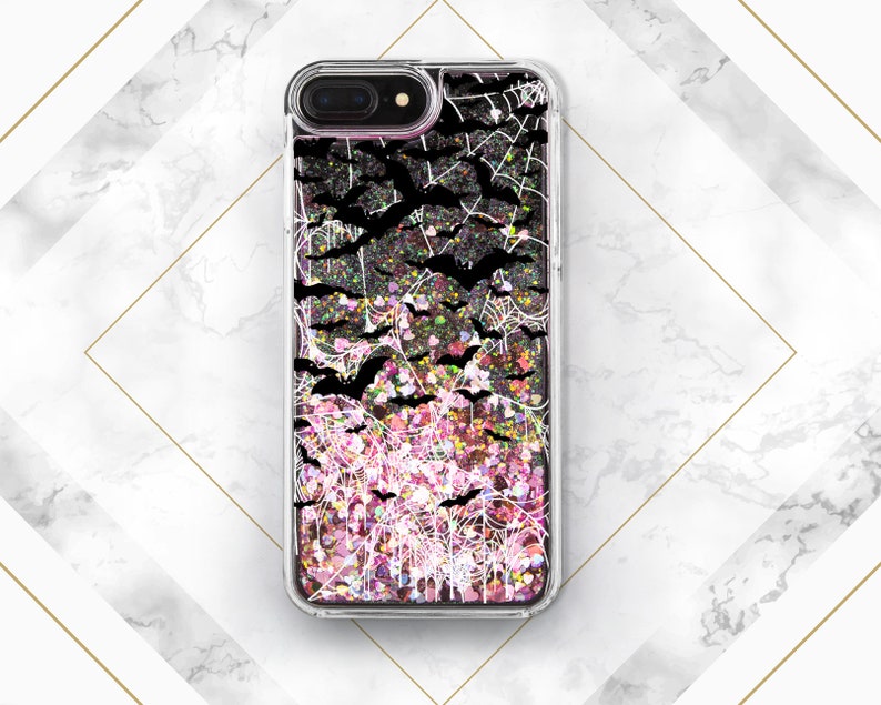 May include: A clear phone case with a glittery pink and black design featuring bats and spiderwebs.