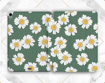 May include: Green tablet case with a daisy pattern. The case is open, revealing the interior. White daisies with yellow centers are scattered across the green surface. The case is designed to protect a tablet.