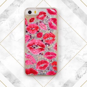May include: A clear phone case with a silver glitter background and a pink and red lip print.