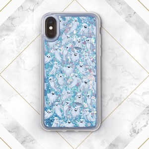 Puede incluir: Una funda transparente para tel&eacute;fono con un fondo de purpurina azul y un patr&oacute;n de fantasmas blancos. La funda est&aacute; dise&ntilde;ada para un iPhone.