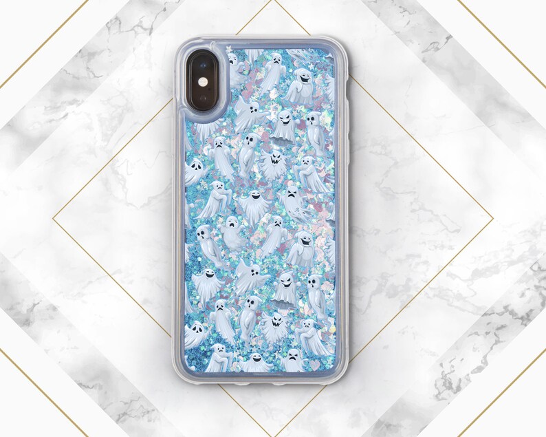 Puede incluir: Una funda transparente para tel&eacute;fono con un fondo de purpurina azul y un patr&oacute;n de fantasmas blancos. La funda est&aacute; dise&ntilde;ada para un iPhone.