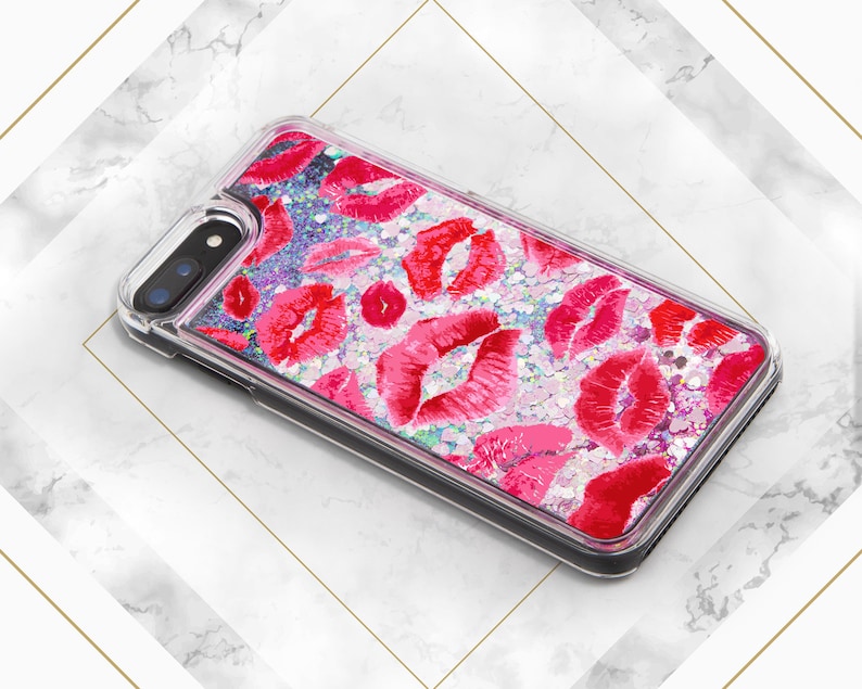 May include: A clear phone case with a glittery pink and white background and red lips printed on it.