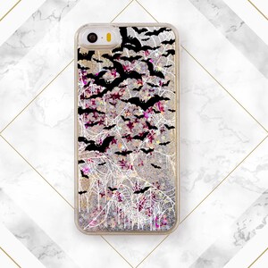 May include: A clear phone case with a glittery background and a black and white design of bats and spiderwebs.