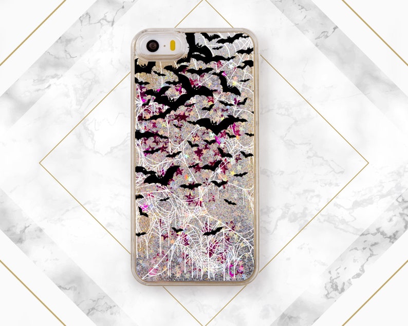 May include: A clear phone case with a glittery background and a black and white design of bats and spiderwebs.