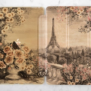 Op de afbeelding: Een iPad-hoes in vintage stijl met een bloemenpatroon en een aquarel-illustratie van de Eiffeltoren in Parijs, Frankrijk. De hoes heeft een beige achtergrond met bruine en roze bloemen.