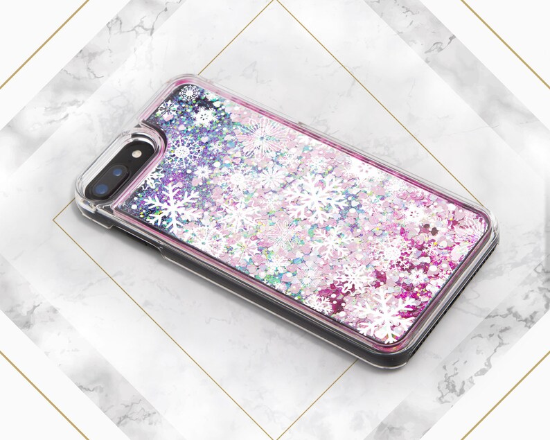 May include: A clear phone case with a pink, white, and blue glitter design. The glitter is shaped like snowflakes and is moving around inside the case.