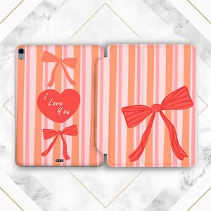 May include: A pink and orange striped tablet case with red bow and heart designs. The heart has the text "I Love You". The case is open, revealing the interior design. The case is designed to protect a tablet.