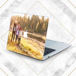 May include: A laptop computer with a custom design featuring a family of four walking in a woodland setting. The design includes a lake and trees in the background.