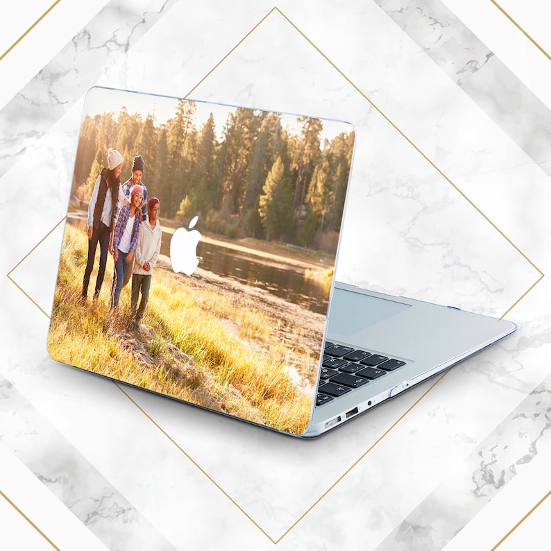 May include: A laptop computer with a custom design featuring a family of four walking in a woodland setting. The design includes a lake and trees in the background.
