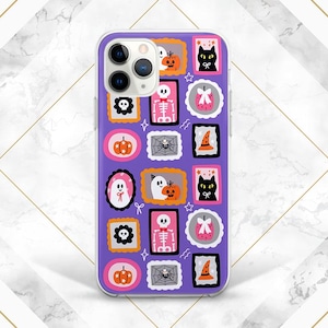 May include: A purple smartphone case featuring a repeating pattern of framed Halloween-themed illustrations, including ghosts, pumpkins, black cats, skeletons, spiders in webs, and witch hats, all rendered in a colourful, graphic art style.