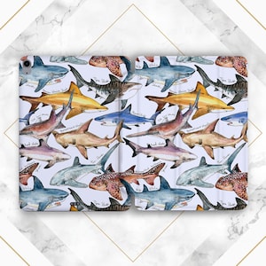 May include: A white phone case with a repeating pattern of different types of sharks, including a tiger shark, a hammerhead shark, a reef shark, a whitetip reef shark, a bull shark, a nurse shark, a whale shark, and a moon shark. The case is made of a durable material and is designed to protect your phone from scratches and bumps.