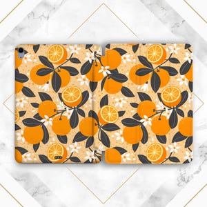 May include: A tablet case with a pattern of orange slices and leaves on a light orange background. The case is made of a durable material and has a sleek design.