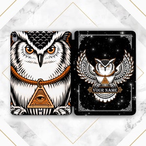 Könnte beinhalten: Zwei Handyhüllen mit schwarzem Hintergrund und einem weißen Eulen-Design. Die Eule trägt eine goldene Schnur um den Hals und ein Dreieck mit einem Auge in der Mitte. Der Text "YOUR NAME" befindet sich am unteren Rand der Hülle.