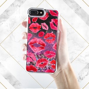 May include: A clear phone case with a glittery pink and purple background and a pattern of red lips.