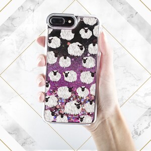 May include: A clear phone case with a pink and black glitter background and a white sheep pattern.