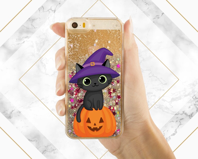 May include: A black cat wearing a purple witch hat sits on top of an orange pumpkin with a carved jack-o'-lantern face. The image is on a gold glitter phone case.