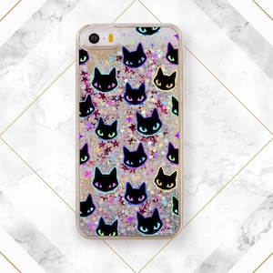 May include: A clear phone case with a glittery background and black cat silhouettes. The case has a silver border and a black camera hole.