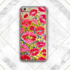 May include: A clear phone case with a gold glitter background and red lips printed on it.