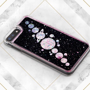 May include: A black glitter phone case with a pink and iridescent glitter design of planets and stars.