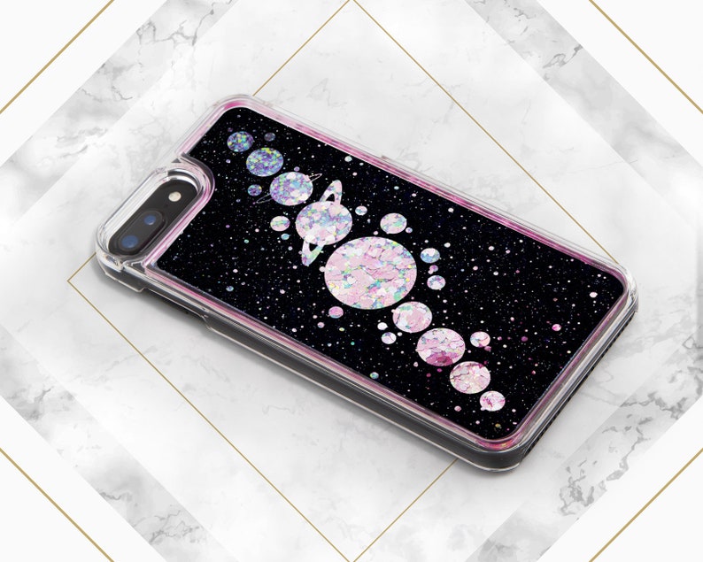 May include: A black glitter phone case with a pink and iridescent glitter design of planets and stars.