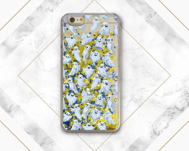 Puede incluir: Una funda de tel&eacute;fono transparente con un dise&ntilde;o de fantasmas blancos y purpurina dorada sobre un fondo azul.