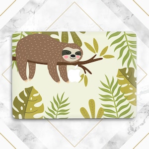 May include: A laptop skin with a cartoon sloth hanging from a branch with green leaves. The sloth is brown with a light brown belly and has a pink nose and a smile. The background is a light green with a white apple logo.