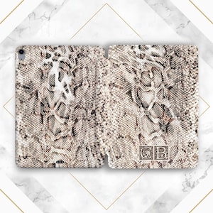 May include: A white and brown snakeskin patterned iPad case with the initials "CB" in a gold frame.