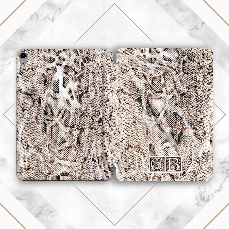 May include: A white and brown snakeskin patterned iPad case with the initials "CB" in a gold frame.