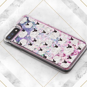 May include: A clear phone case with a silver glitter background and a repeating pattern of pink sheep. The case has a black border and a camera cutout.