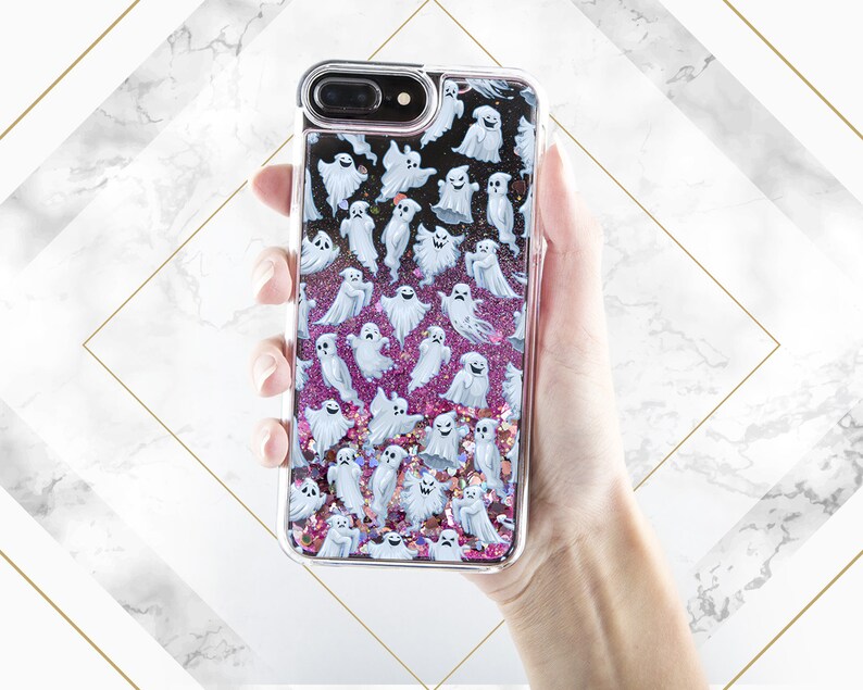 Puede incluir: Una funda transparente para tel&eacute;fono con un fondo de purpurina rosa y blanca y un patr&oacute;n de fantasmas blancos.