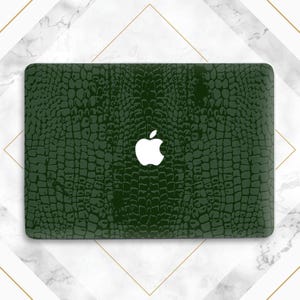 May include: A green laptop skin with a crocodile pattern and a white Apple logo.