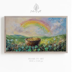May include: An oil painting of a rainbow arching over a green field with a wooden bowl filled with gold coins. The artwork is framed in a light-colored wooden frame. The painting has a dreamy, impressionistic style, with visible brushstrokes.