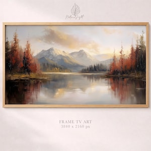 May include: Landscape painting in a light wood frame. The artwork depicts a serene lake scene with mountains in the background. Trees with red and orange foliage line the water's edge. The sky has soft, warm colors. Text at the bottom reads "FRAME TV ART 3840 x 2160 px".