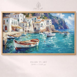 May include: A framed art print of a coastal scene. White buildings with brown roofs line the shore, with boats in the turquoise water. A mountain rises in the background under a blue sky. The frame is light brown. Text at the bottom reads "FRAME TV ART 3840 x 2160 px."