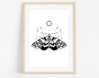 May include: Framed art print featuring a detailed black and white illustration of a moth with intricate wing patterns. The moth is centered against a white background, with geometric shapes and celestial elements. The artwork is displayed in a light wood frame.