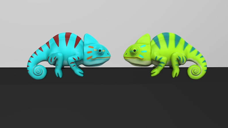 May include: Two toy chameleons facing each other. The chameleon on the left is blue with red stripes and orange accents. The chameleon on the right is green with blue stripes.