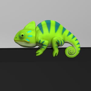 May include: A green and blue chameleon figurine with a curled tail. The chameleon is perched on a black surface.