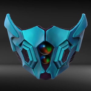 Puede incluir: Una máscara futurista azul y morada con un diseño geométrico y dos orbes brillantes en el centro.