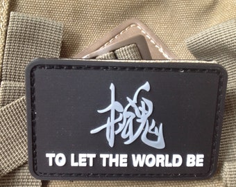 May include: Black patch with white text and a gray Chinese character. The text reads "To Let The World Be".